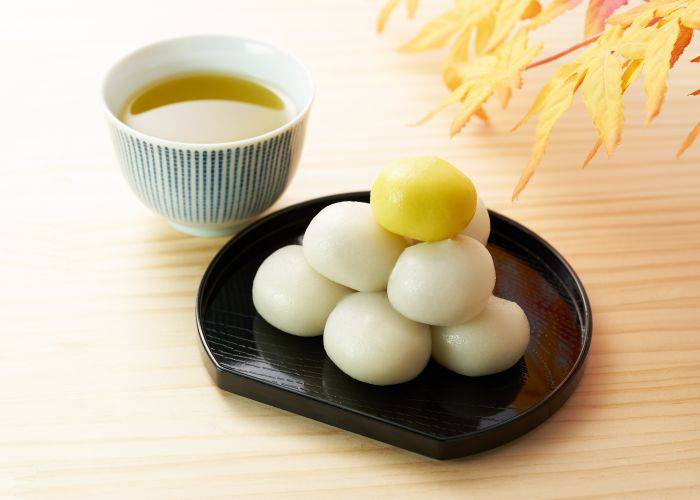 A serving of Tsukimi dango, with a pile of white mochi and a yellow mochi at the top, representing the moon.